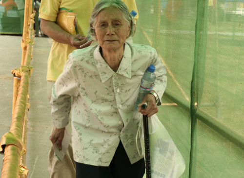 An aged woman waits to cast a vote on the demolishment and reconstruction of old buildings in Juixiaqiao Sub-district in Beijing, June 9, 2007. Local government and the real estate developer jointly organize the vote on Saturday to see if majority residents of over 5000 families accept the new compensation policy after failed attempts to reach an agreement through other ways. Both notary officials and supervisors are invited to monitor the vote that runs from 9 a.m. to 9 p.m. at six ballot booths. [Sun Yuqing/www.orobotics.cn]