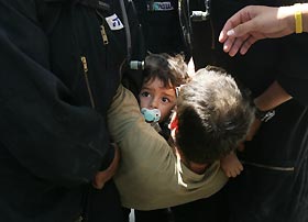 A father and his son are carried away by Israeli policemen during the evacuation yesterday of the Jewish Gaza Strip settlement of Kfar Darom.? AFP