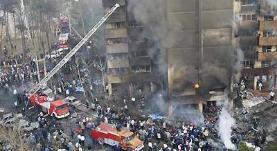 Smoke and flames rise from a building where a plane crashed in Tehran December 6, 2005. An Iranian military plane carrying at least 94 people crashed in flames into a Tehran apartment block on Tuesday, killing all those on board, police said.