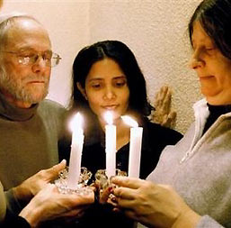 Members of Christian Peacemaker Teams, from left, Jill Pritchard-Scott, Father Bob Holmes, Arunthathy Ratnasingham and Lyn Adamson hold candles during a vigil in Toronto, Canada Saturday Dec. 10, 2005.