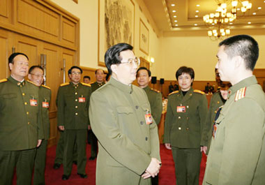 President Hu Jintao (L Front) talks with a member of the delegation of the Chinese People's Liberation Army (PLA) to the Fourth Session of the Tenth National People's Congress (NPC), in Beijing, March 11.(Xinhua